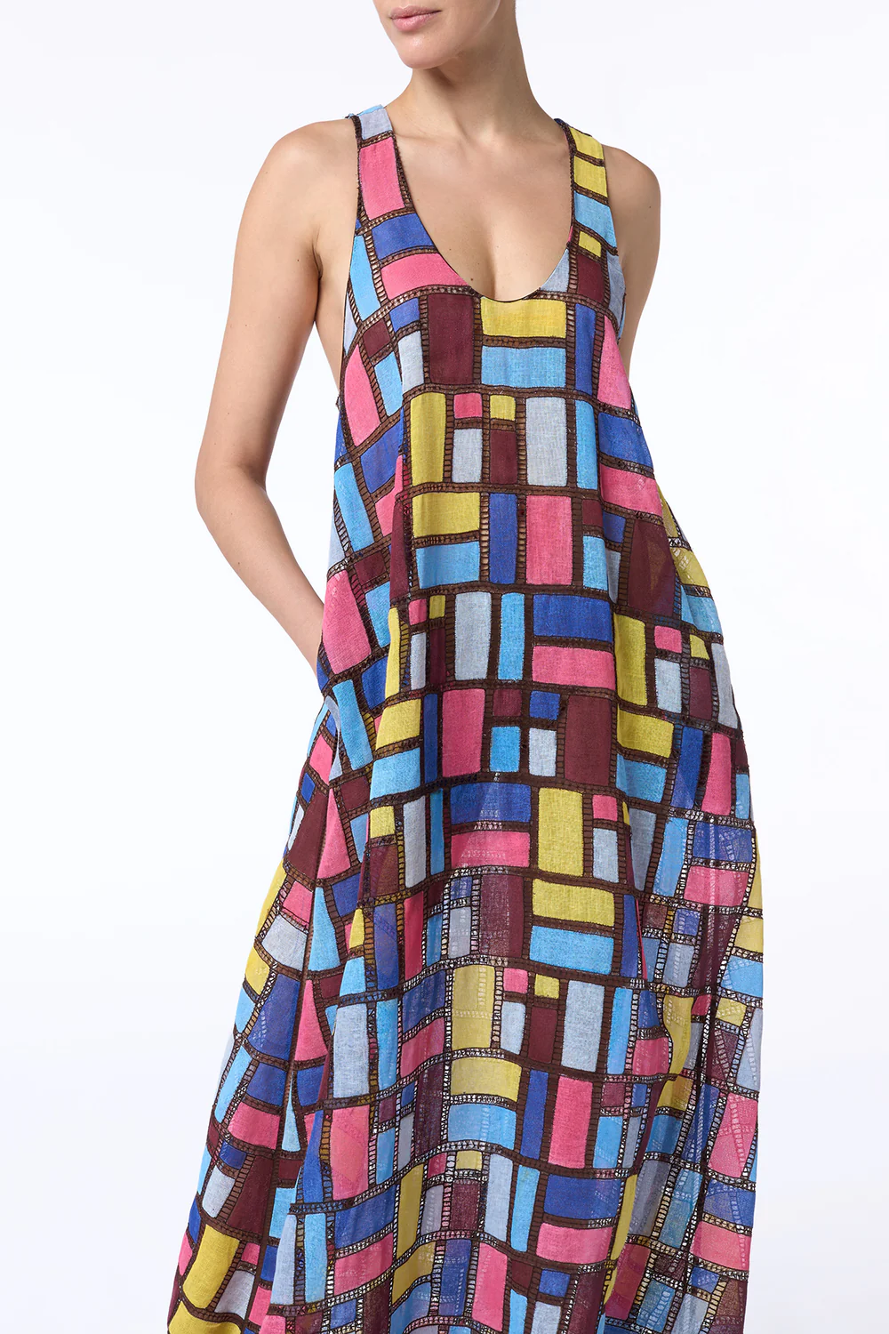 A model showcasing a colorful patchwork midi dress featuring geometric shapes in vibrant hues, designed by Gabriela Hearst.