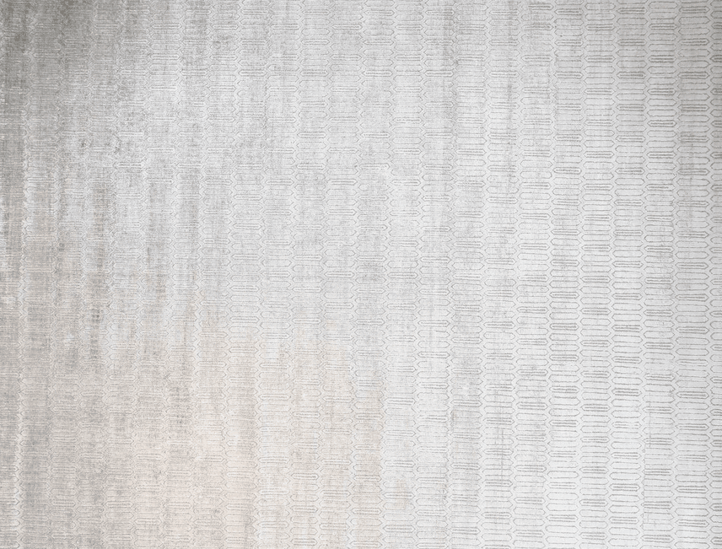 A textured beige rug with a subtle pattern, featuring elongated shapes in a tonal design.