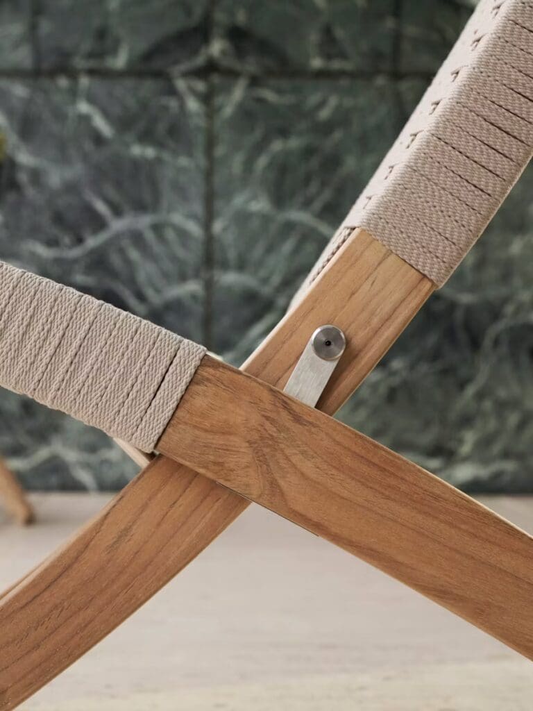 Close-up view of a wooden chair frame with beige woven fabric detail, highlighting the intersection and connection mechanism.