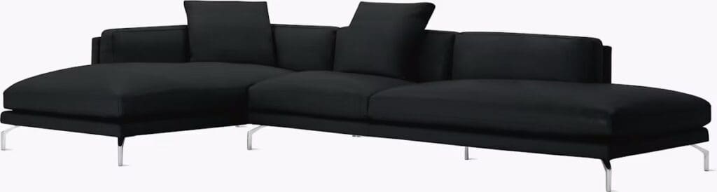 A modern black sectional sofa with sleek lines and chrome legs, featuring cushions for comfort.