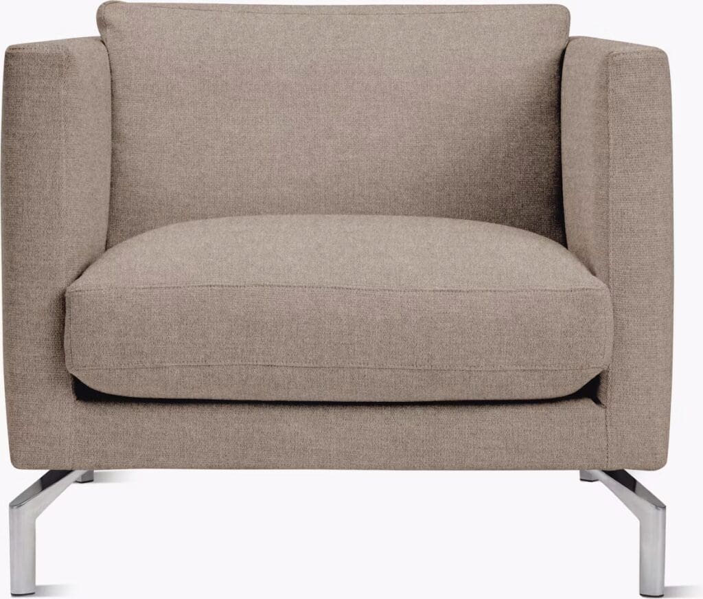 A modern, minimalist armchair with a beige fabric upholstery and stainless steel legs.