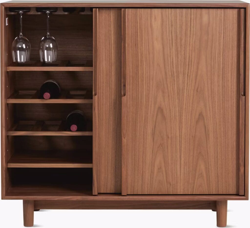 A wooden cabinet with a minimalistic design featuring two sliding doors, shelves for wine bottles, and a space for wine glasses.