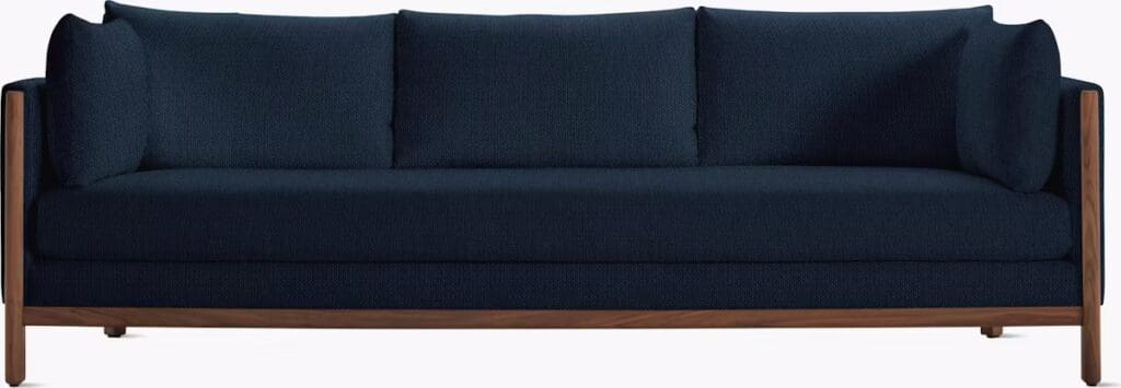 A modern navy blue sofa with three back cushions and wooden armrests.