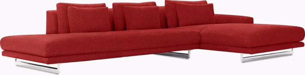 Modern red sectional sofa with cushions and sleek chrome legs