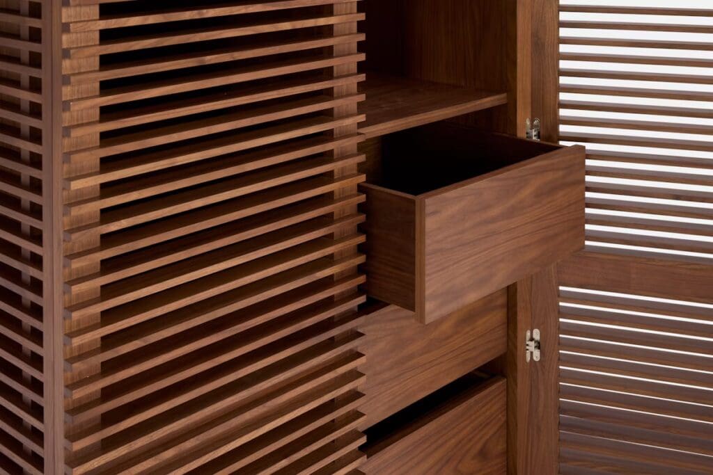 Close-up of a modern wooden cabinet featuring horizontal slats and an open drawer.