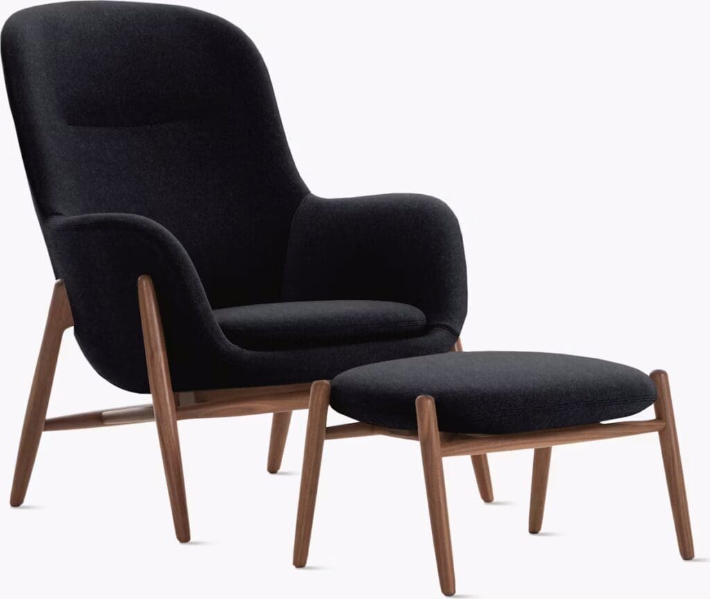 A modern black upholstered armchair with a matching ottoman, featuring wooden legs.
