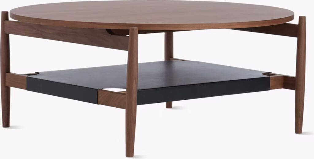 A modern round wooden coffee table with a black shelf underneath, featuring a sleek design and sturdy legs.