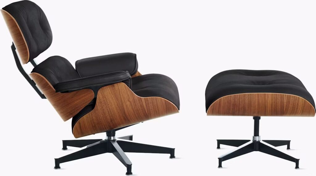 A modern Eames Lounge Chair and Ottoman set featuring a sleek black leather seat and walnut wood accents, designed for comfort and style.