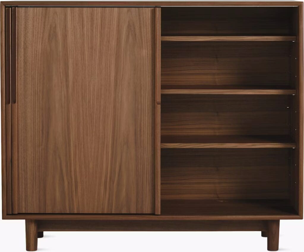 A wooden cabinet with a sliding door and open shelving, showcasing its natural finish.