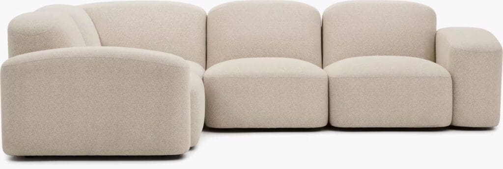 Modern, light-colored sectional sofa with rounded edges, designed for comfort and style.