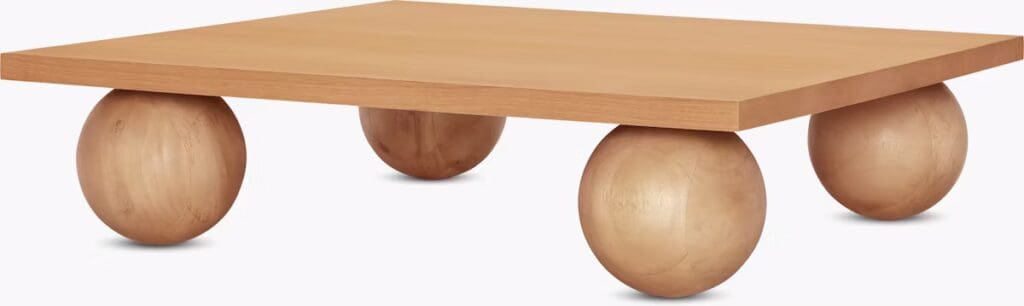 A stylish low coffee table with a square top supported by rounded wooden legs, showcasing a modern design.