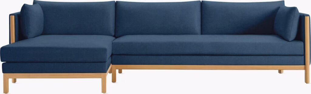 A modern blue sectional sofa with a wooden frame, featuring a chaise lounge on one side and plush cushions.