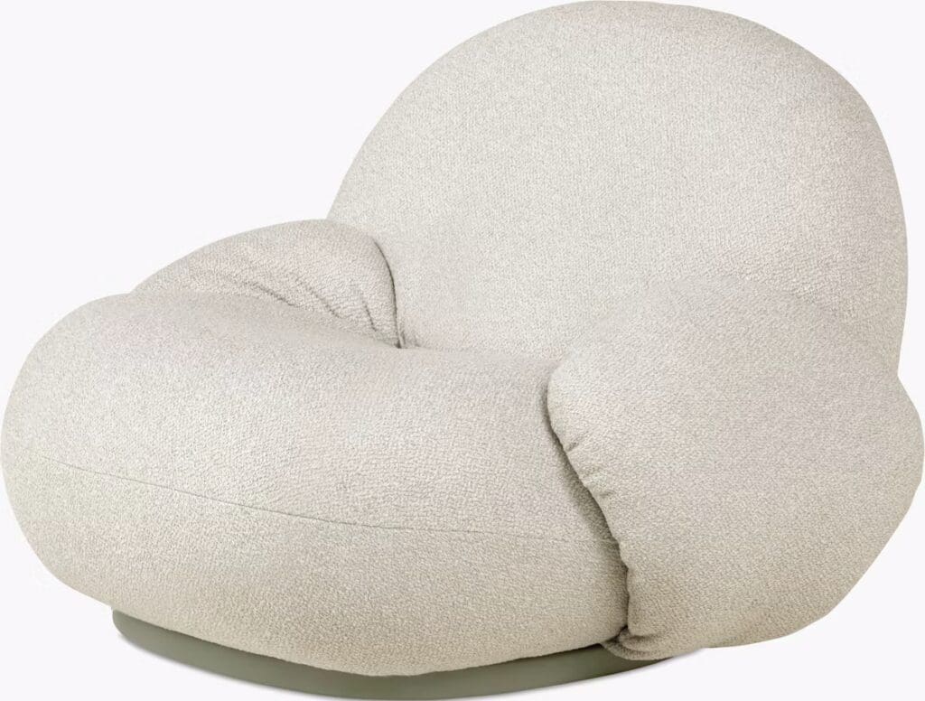 A round, plush armchair with soft, textured fabric in a light gray color, designed for comfort and modern aesthetics.