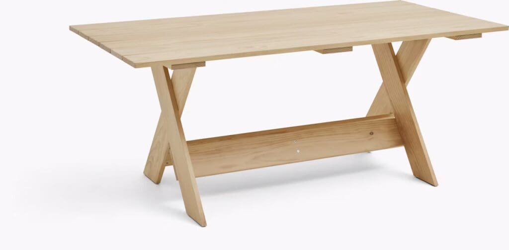 A modern wooden dining table with a flat rectangular top and crisscrossed legs, showcasing a natural wood finish.