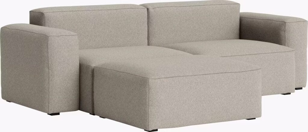 A modern gray sectional sofa with a low profile and minimalist design, featuring wide armrests and a modular structure.