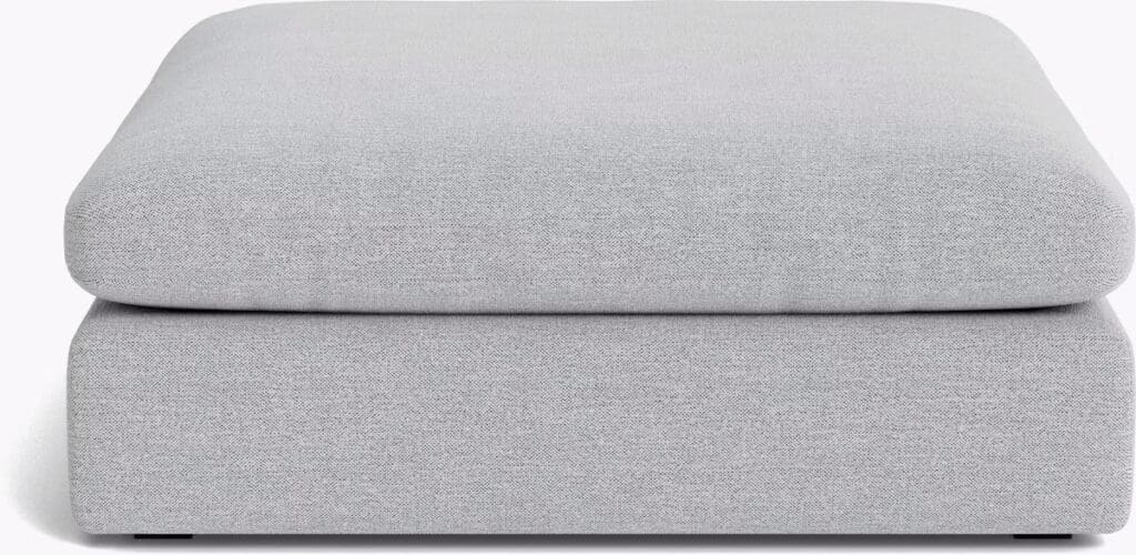 A plush gray ottoman featuring a flat, thick cushion design, perfect for adding comfort and style to a contemporary living space.