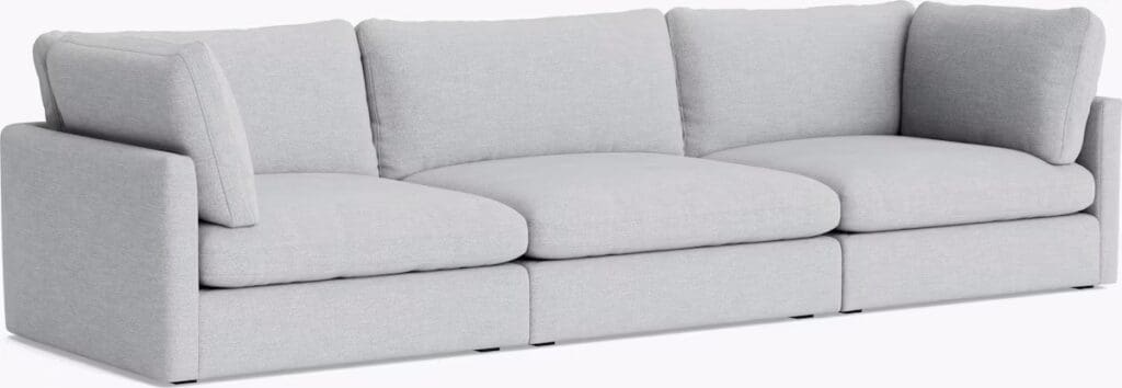 A modern light gray sectional sofa with plush cushions and a contemporary design.