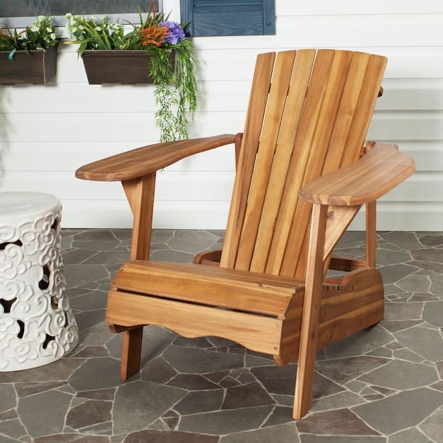 Adirondack chair made of wood next to a decorative side table on a patterned stone patio, with potted plants in the background.