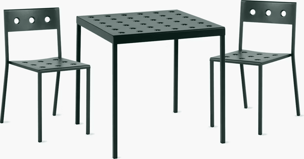 Modern outdoor table and two chairs with perforated design, suitable for outdoor dining.