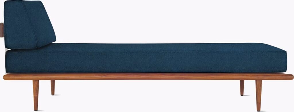 A modern chaise lounge featuring a dark blue fabric cushion and a wooden frame with angled legs.
