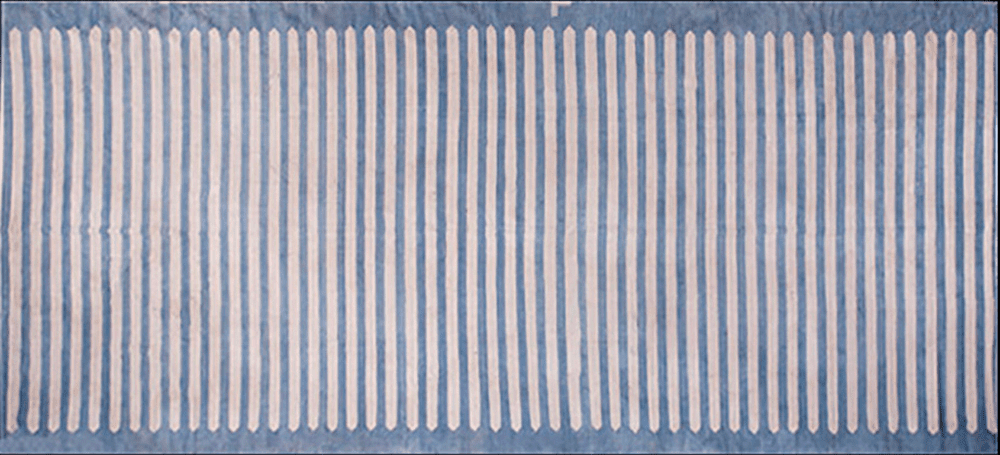 A blue rug featuring a pattern of vertical white stripes spaced evenly across its surface.