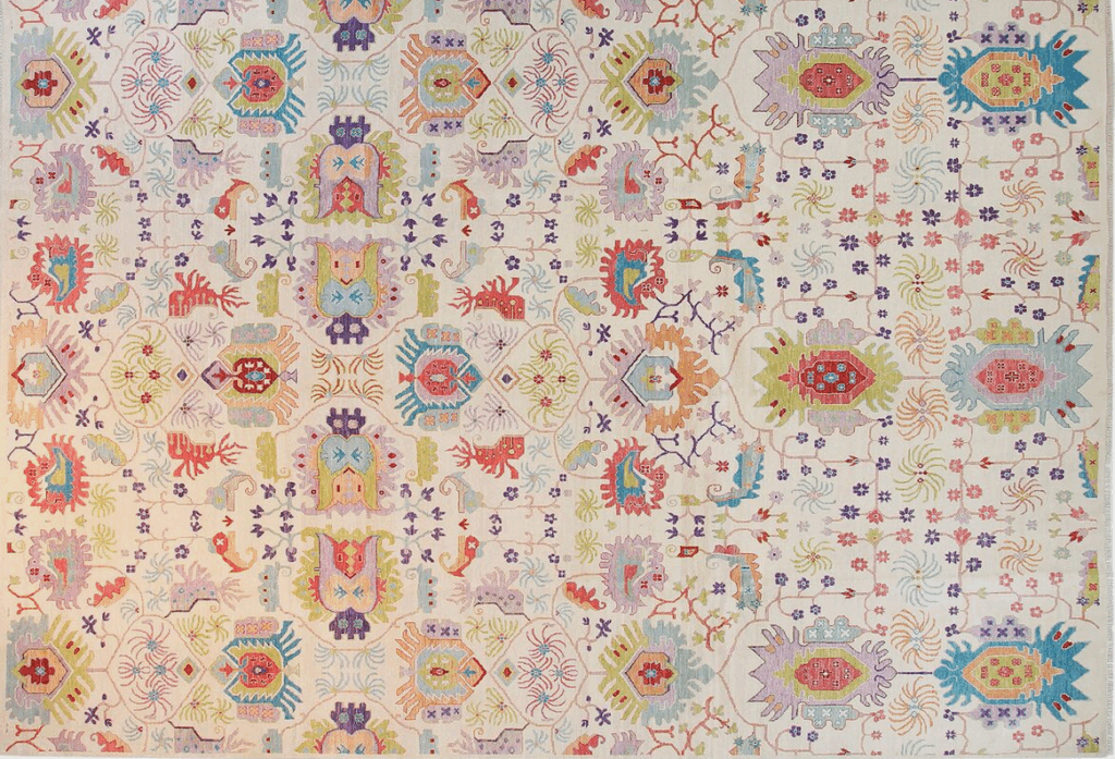 Vibrant and intricate vintage rug featuring a colorful floral design in shades of pink, orange, blue, and green, with decorative motifs and patterns.