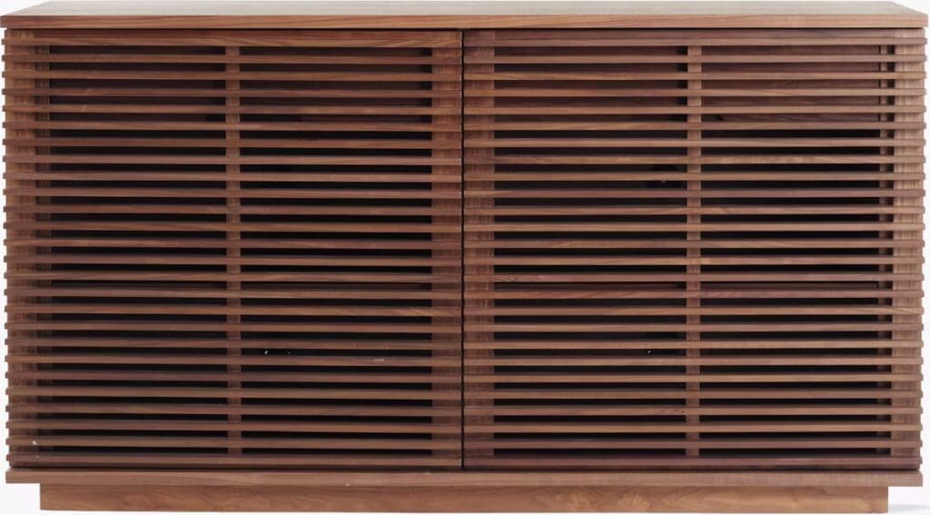 A wooden cabinet with a slatted design, featuring two doors and a smooth top surface.