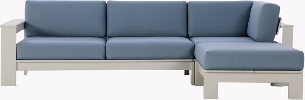 Modern outdoor sectional sofa with blue cushions and a light-colored frame.