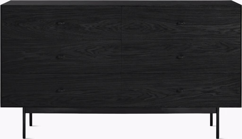 A modern black dresser with four spacious drawers and sleek metal handles, featuring a minimalist design and standing on slender metal legs.