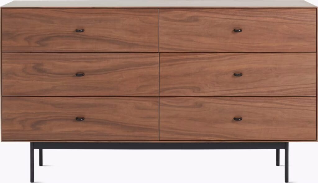 A modern wooden dresser with six drawers, featuring a walnut finish and black handles, elegantly supported by a black metal frame.