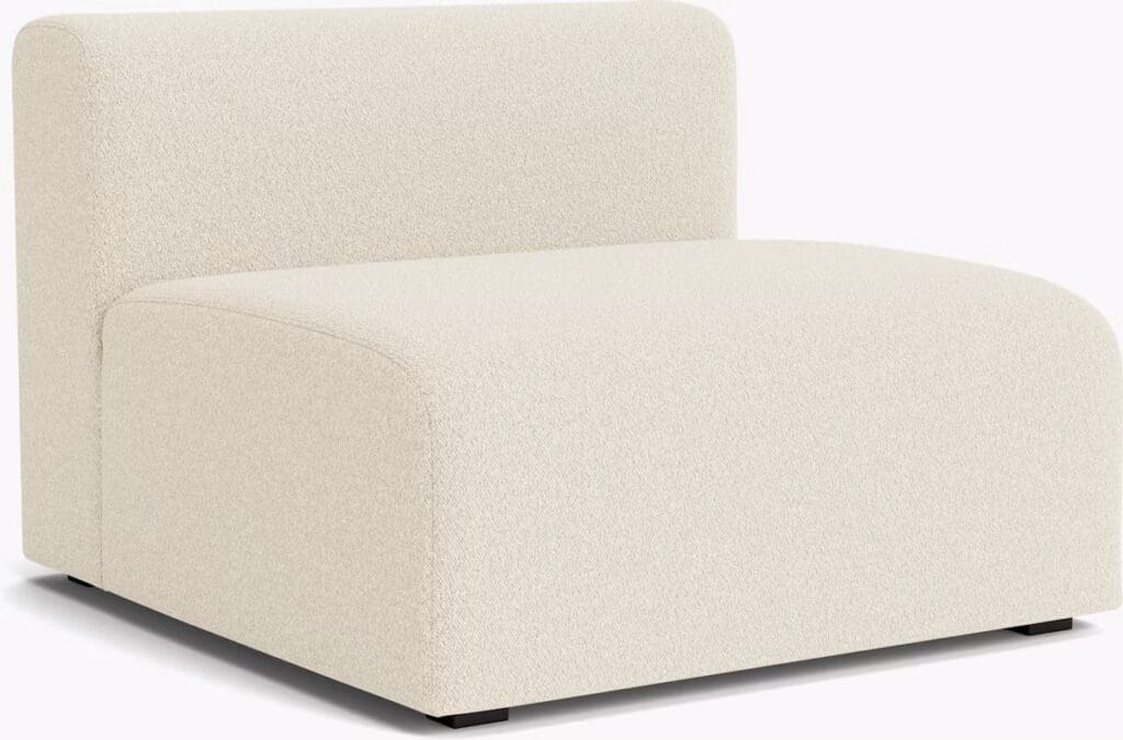 A modern cream-colored chaise lounge with a minimalist design, featuring rounded edges and a soft texture.