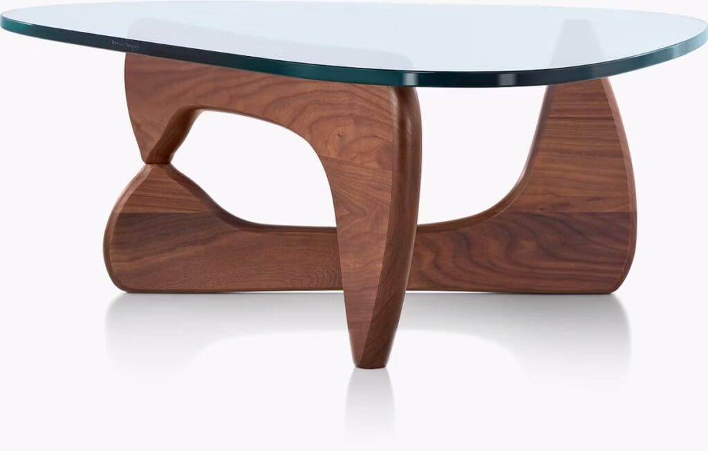 A modern coffee table with a curved wooden base and a round glass top, showcasing a sleek and artistic design.