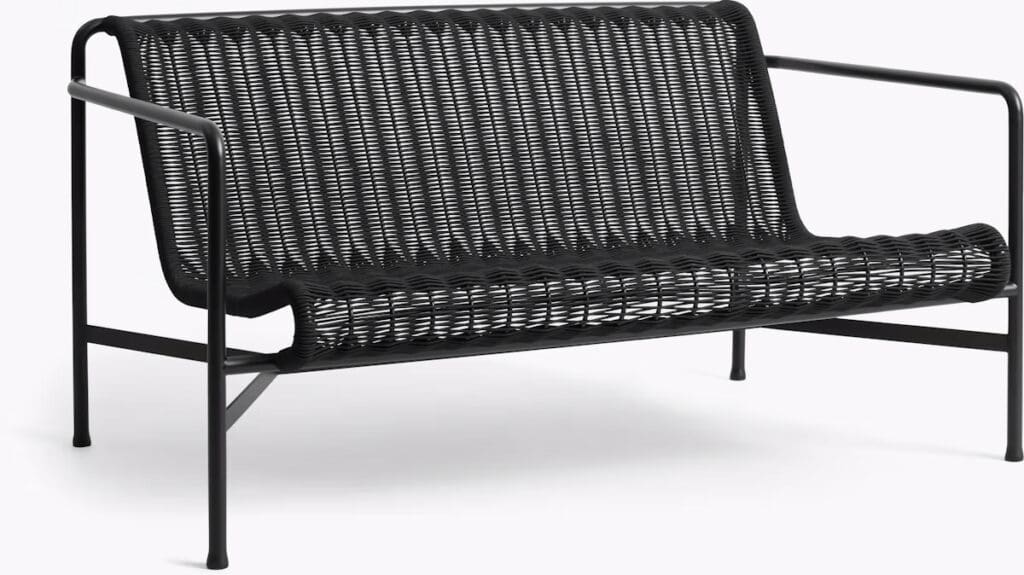 A modern black sofa with a minimalist design, featuring woven seating and a sturdy metal frame.