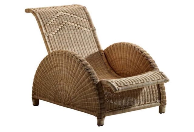 Stylish wicker lounge chair with a curved design, ideal for outdoor relaxation.