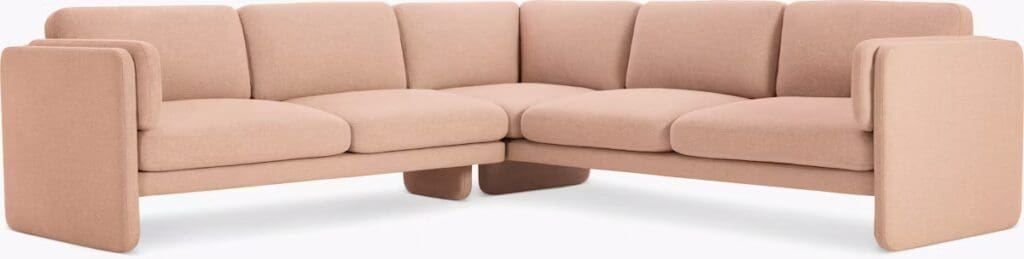 A modern pink sectional sofa with a minimalist design, featuring plush cushions and clean lines, perfect for a contemporary living space.