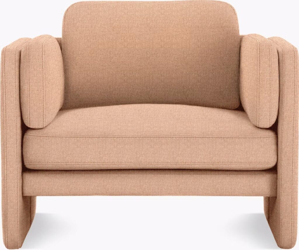 A modern armchair with a rounded design and soft, beige upholstery, featuring plush cushions and unique side arm details.