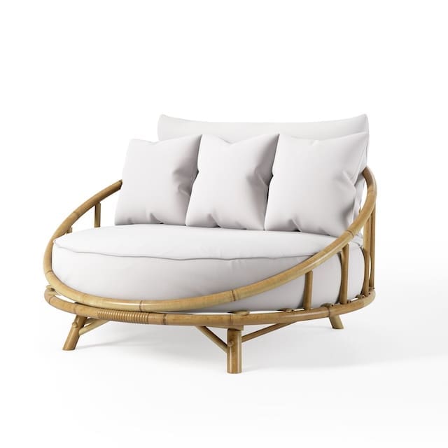 Curved bamboo outdoor chair with white cushions, designed for relaxation.