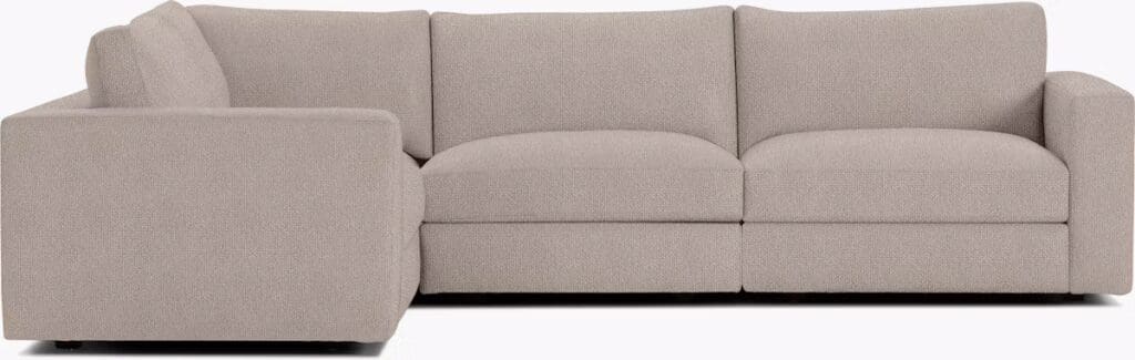A modern beige sectional sofa with a clean design, featuring plush cushions and a minimalist aesthetic.