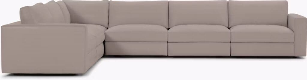 A modern beige sectional sofa with clean lines and a minimalist design, featuring a spacious left arm and multiple seating sections.