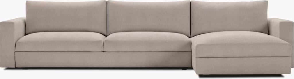 A modern beige sectional sofa with plush cushions and a chaise end, designed for comfort and relaxation.