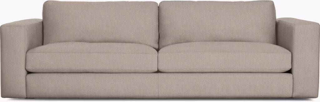 A modern, beige, upholstered sofa with thick cushions and wide armrests, designed for comfort and style.