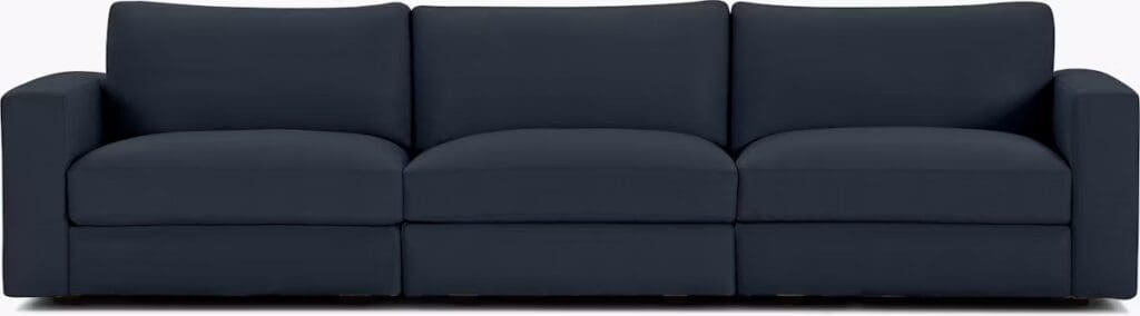 A modern dark blue sectional sofa featuring a sleek and minimalist design, with plush cushions and clean lines.