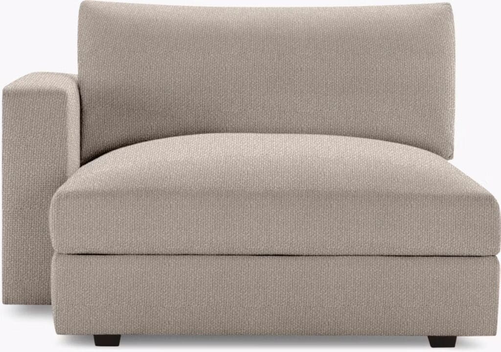 A beige, modern chaise sectional with a rounded backrest and minimalist design.