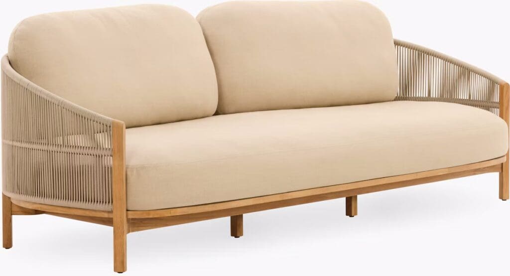 Beige outdoor sofa with rounded backrest and wooden base, designed for luxurious living spaces.