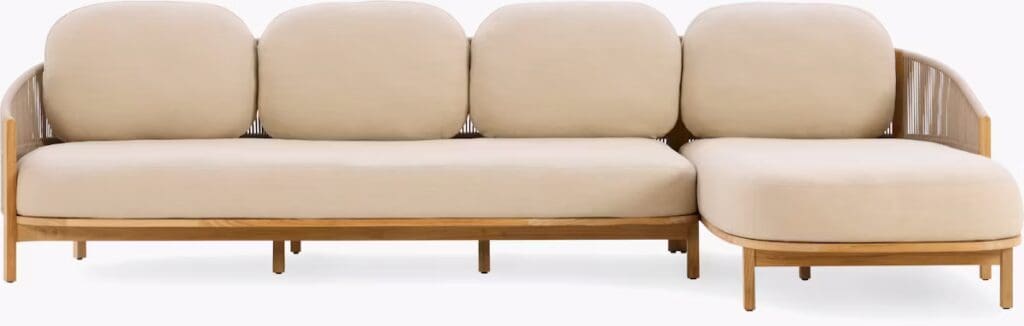 A modern beige sectional sofa with rounded cushions and a wooden frame, featuring a chaise section on one side.