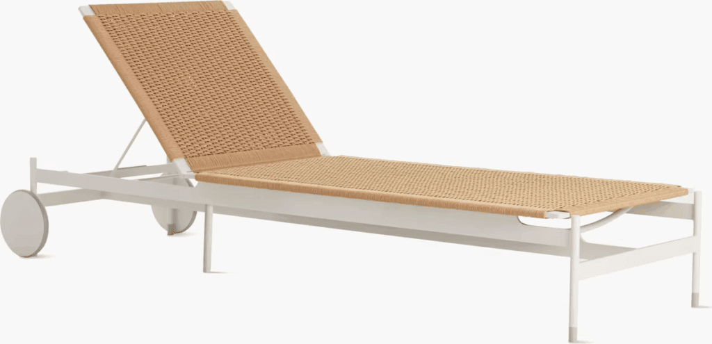Lounge chair with a woven straw seat and white metal frame, designed for outdoor use.