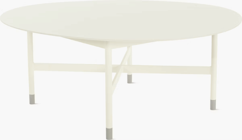 Minimalist circular table with a white top and light-colored legs, featuring gray foot accents.
