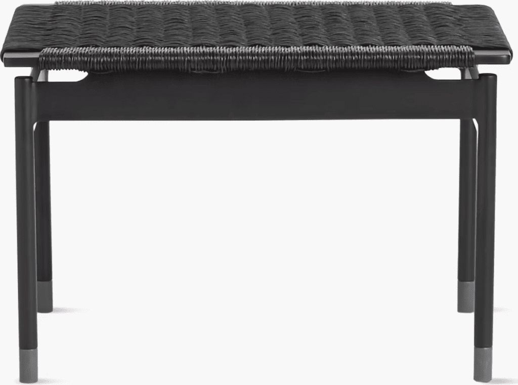 Stylish black outdoor side table with a woven top and sleek metal legs.