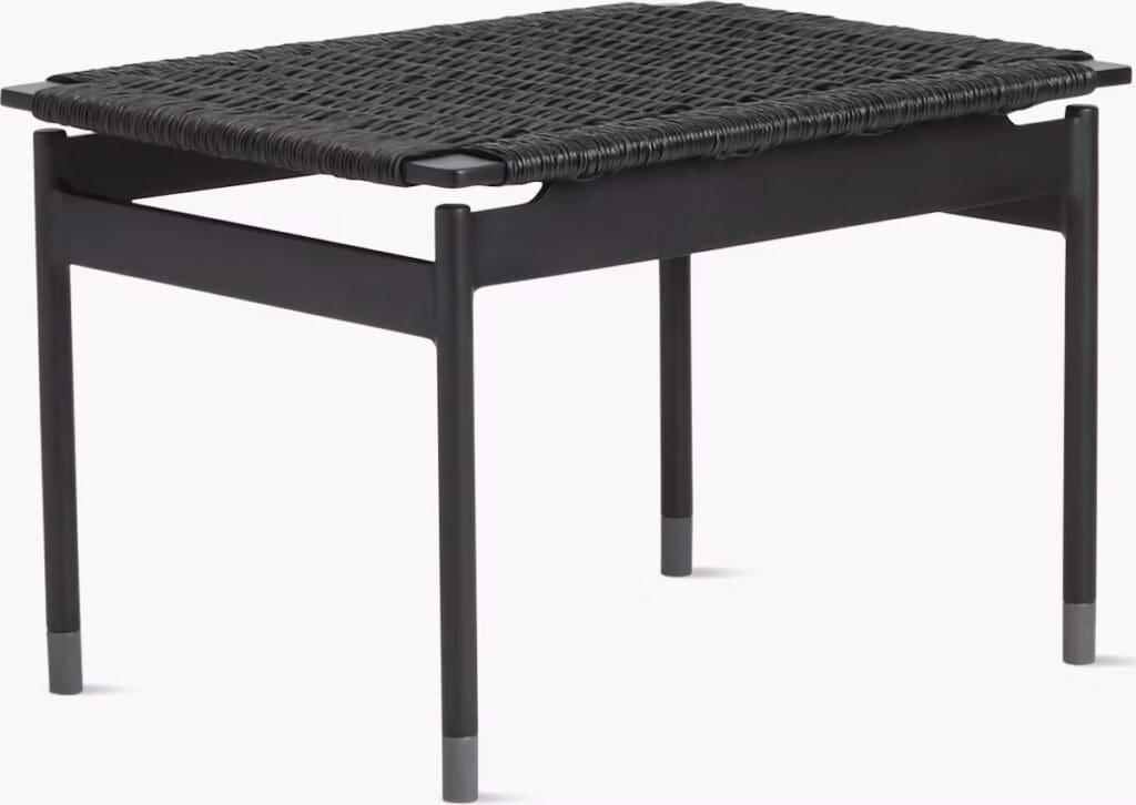 A modern black coffee table with a woven top and sleek legs, showcasing a contemporary design suitable for stylish living spaces.