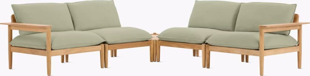 Modern outdoor lounge seating with light green cushions and wooden frame, designed for comfort and style.